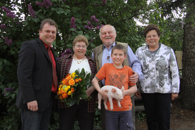 Ein Leben für die Landwirtschaft  Goldene Hochzeit im Hause Adolf Konrad in Kürnach  Rita und Adolf Konrad feierten Goldene Hochzeit in Kürnach. Neben Bürgermeister Thomas Eberth, der 2. Bürgermeisterin Sieglinde Bayerl gratulierten viele Bekannte, Freunde und Verwandte und vor allem sieben Enkelkinder. Das Leben des Jubelpaares war geprägt von der Landwirtschaft und dem eigenen Betrieb. Dabei ist Rita Konrad immer die gute Seele des Hofs und des Haushaltes gewesen. Während Adolf Konrad weit über die Grenzen Kürnachs in verschiedenen Ämtern und auch musikalisch tätig war, stärkte ihm seine Frau den Rücken und kümmerte sich oftmals um Kinder, Enkel, Stall und die laufenden Geschäfte. Adolf Konrad ist aktiver Siebener in Kürnach, war seit Gründung der Jagdgenossenschaft im Jahr 1970 bis 2001 deren Vorsitzender und wurde für 50 Jahre Mitgliedschaft bei der Freiwilligen Feuerwehr geehrt. Besonders herausragend waren seine Verdienste um die Gemeinde Kürnach. So war Adolf Konrad Gemeinderat von 1972 – 2002 und 3. Bürgermeister von 1978-1984 sowie 2. Bürgermeister von 1984-1990. 2002 erhielt er die Verdienstmedaille in Bronze der Gemeinde. Vor seinem Ausscheiden aus dem Gemeinderat war er mit 30jähriger Zugehörigkeit der dienstälteste Rat der CSU-Kürnach seit Bestehen des CSU-Ortsverbandes 1957.  „Seine kameradschaftliche Art und die Eigenschaft, Probleme direkt  anzusprechen und nicht „um den heißen Brei“ zu reden, zeichneten ihn aus“, so Bürgermeister Eberth bei den Lobesworten. Bei insgesamt fünf Kommunalwahlen erhielt er das Vertrauen der Kürnacherinnen und Kürnacher. Seine Stimme hatte Gewicht im Gremium. Immer wieder zeichnete er sich aus als engagierter Vertreter der Landwirtschaft und Kenner des Ortsgeschehens. Adolf Konrad wurde mit der Verdienstmedaille der Gemeinde Kürnach ausgezeichnet. Legendär waren auch seine Auftritte bei der Show- und Stimmungskapelle „Die Kürnacher“. Dort führte er als Vorsitzender den Verein und sorgte stets für tolle Stimmung bei den verschiedensten Festen. Berühmt waren seine Auftritte als Dschingis Khan. Seine Frau Rita war neben ihrer Arbeit in Haus und Hof auch als Schöffin tätig. Beide kannten sich seit der Schulzeit und haben bald Interesse für einander gehabt. Aus der Ehe gingen zwei Söhne und sieben Enkel hervor. Besonders stolz sind beide darauf, dass ihr Hof an den Sohn übergeben werden konnte und auch die Enkel Interesse an der Landwirtschaft haben. Mittlerweile ist es der einzige Hof mit deutlich über 100 Ferkeln in Kürnach. Beide Jubilare helfen noch aktiv mit und Adolf Konrad bearbeitet nach wie vor gerne die Felder.  Bild: Gratulierten dem Jubelpaar: Bürgermeister Thomas Eberth und 2. Bürgermeisterin Sieglinde Bayerl. Enkel Johannes Konrad wünscht mit einem kleinen Ferkel Glück und Gesundheit für seine Großeltern Rita und Adolf Konrad. 